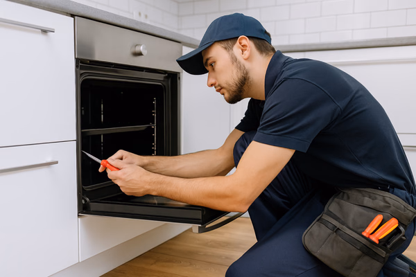 Appliance repair technician fixing a refrigerator
