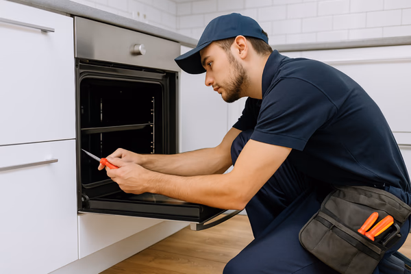 Appliance repair technician fixing a refrigerator